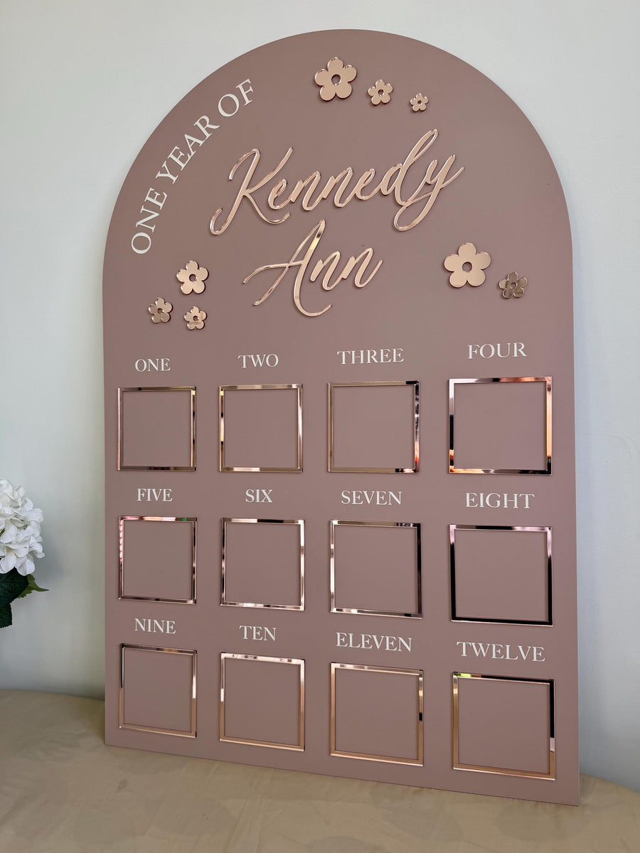 Custom first birthday photo board with floral theme and one year of photos
