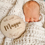 Personalised wooden birth announcement disc featuring custom newborn name in natural finish