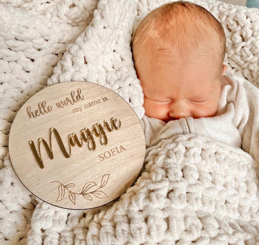 Personalised wooden birth announcement disc featuring custom newborn name in natural finish